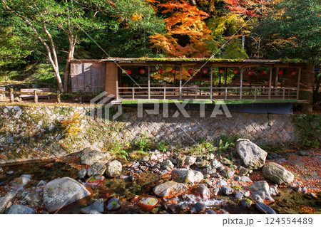 Wooden terrace by canal of Minoh waterfall park in autumn, Osaka 124554489
