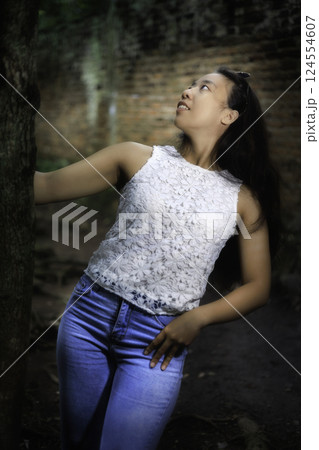 Woman by the tree in the old garden 124554607