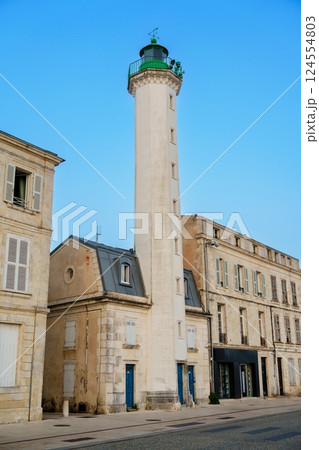 Historic Lighthouse Standing Tall Near Beautiful Harbor Buildings Under Bright Clear Blue Sky 124554803