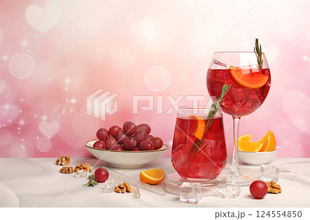 Glasses of grape cocktail, red wine and juice with grape berries, ice and citrus slices on elegant background with spring sakura flowers, bar and summer party concept, restaurant and cafe advertising 124554850