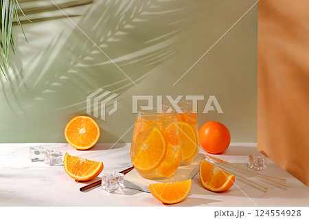 Modern still life with citrus fruits, Orange juice and oranges on elegant kitchen table with long hard shadows. minimal detox diet concept, summer vitamin drinks, selective focus, space for text 124554928