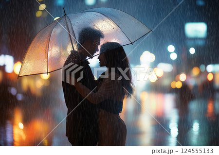 A couple embraces under an umbrella in a rainy city, surrounded by illuminated nighttime ambiance, evoking love and serenity. Romantic couple under a glowing umbrella during nighttime rain 124555133