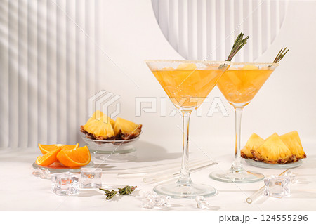 Cocktail with tequila, rum and vodka with pineapple slices, orange, ice and rosemary. Summer party concept. Diet drink for body detox and weight loss, advertising for a bar or cafe, menu for a Cocktail with tequila, rum and vodka with pineapple slices, orange, ice and rosemary. Summer party concept. Diet drink for body detox and weight loss, advertising for a bar or cafe, menu for a 124555296