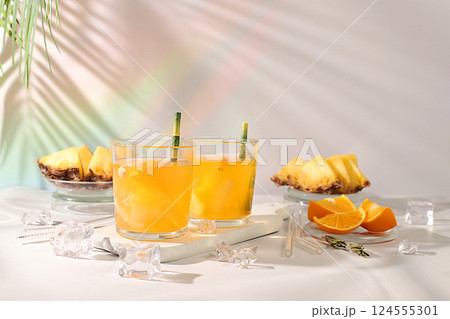 Cocktail with tequila, rum and vodka with pineapple slices, orange, ice and rosemary. Summer party concept. Diet drink for body detox and weight loss, advertising for a bar or cafe, menu for a Cocktail with tequila, rum and vodka with pineapple slices, orange, ice and rosemary. Summer party concept. Diet drink for body detox and weight loss, advertising for a bar or cafe, menu for a 124555301