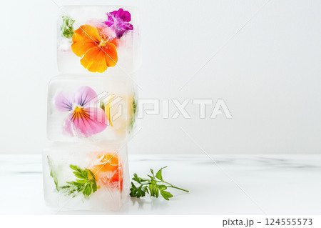 Colorful ice cubes with edible flowers and herbs 124555573