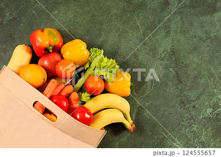 Canvas eco bag with healthy vegan products for weight loss. Lemons, oranges, tomatoes, apples, bananas, carrots, celery and natural juice in a cloth bag, food delivery concept, store advertising Canvas eco bag with healthy vegan products for weight loss. Lemons, oranges, tomatoes, apples, bananas, carrots, celery and natural juice in a cloth bag, food delivery concept, store advertising 124555657
