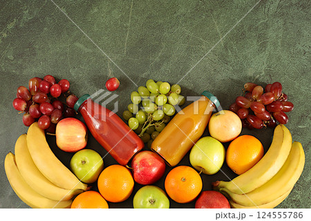 Detox diet and weight loss concept. Healthy vegan products for a healthy lifestyle. Grapes, oranges, pineapple, apples, bananas, nuts and natural juice on a concrete background, store advertising Detox diet and weight loss concept. Healthy vegan products for a healthy lifestyle. Grapes, oranges, pineapple, apples, bananas, nuts and natural juice on a concrete background, store advertising 124555786
