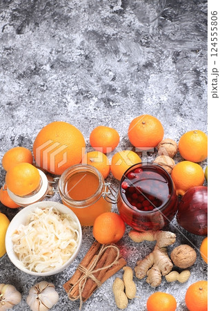 Healthy natural food for the flu and colds. Selection of fresh fruits and vegetables with vitamin C, tangerines, cabbage, cranberries, cinnamon, honey on a concrete table. Organic virus protection 124555806