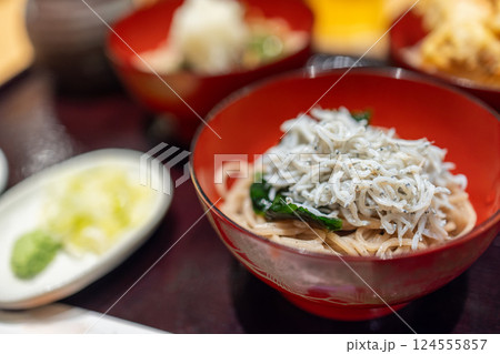 Japanese dish featuring soba noodles topped with fresh shirasu (baby sardines) and green vegetables Japanese dish featuring soba noodles topped with fresh shirasu (baby sardines) and green vegetables 124555857