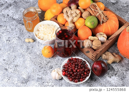 Healthy natural food for the flu and colds. Selection of fresh fruits and vegetables with vitamin C, tangerines, cabbage, cranberries, cinnamon, honey on a concrete table. Organic virus protection Healthy natural food for the flu and colds. Selection of fresh fruits and vegetables with vitamin C, tangerines, cabbage, cranberries, cinnamon, honey on a concrete table. Organic virus protection 124555868