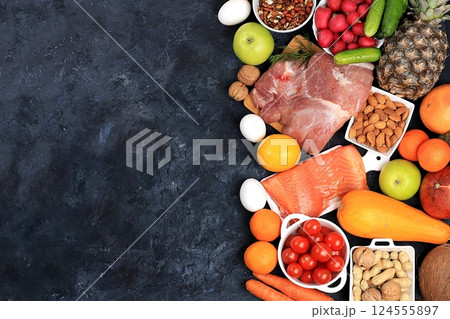 Healthy balanced food with dietary ingredients, vegetables, fruits, nuts, meat, fish for weight loss, healthy lifestyle concept, place for text, selective focus 124555897