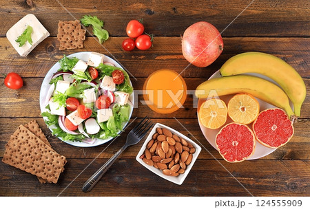 Healthy balanced food with dietary ingredients, vegetable salad with feta cheese and tropical fruits for weight loss, healthy lifestyle concept. Organic anti-virus products 124555909