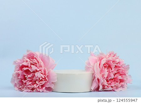 Delicate flowers peonies, roses and empty podium for product display.Spring still life and banner for screen,elegant beauty concept,template for design.Abstract flower arrangement 124555947
