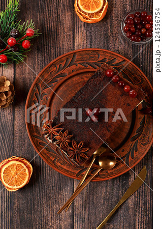 Homemade winter dessert, tiramisu with sweet cream filling, nuts, cinnamon and cranberries. Concept for holiday bakery, seasonal treats and cafe advertising, selective focus Homemade winter dessert, tiramisu with sweet cream filling, nuts, cinnamon and cranberries. Concept for holiday bakery, seasonal treats and cafe advertising, selective focus 124556754