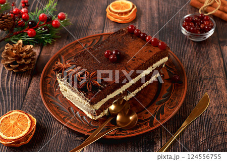 Homemade winter dessert, tiramisu with sweet cream filling, nuts, cinnamon and cranberries. Concept for holiday bakery, seasonal treats and cafe advertising, selective focus 124556755