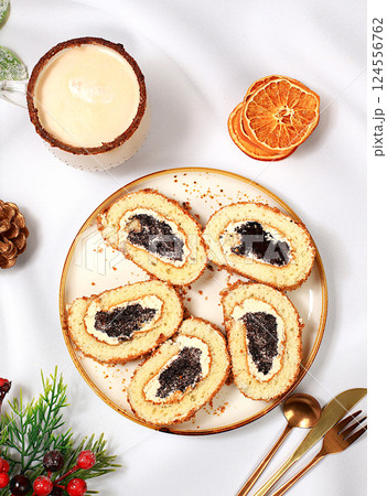 Homemade winter dessert, sponge cake with sweet jam filling, nuts and cinnamon and eggnog.The concept of a festive bakery,seasonal treats and advertising for cafes, selective focus 124556762