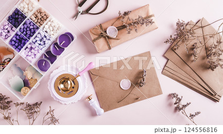 Creative set for sealing envelopes and gifts with wax seal on pink top view web banner 124556816