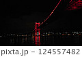 対岸のビルの灯と海に架かる深紅に光る橋 124557482