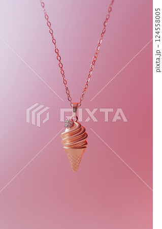 Elegant rose gold ice cream cone necklace on a soft pink background. Rose gold ice cream cone jewelry pendant. Sweets and fast fashion concept. Rip diet, creative jewelry. Summer vibes, holidays. 124558005