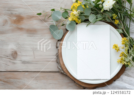Elegant wedding table setting with menu card and floral decoration on wooden surface. Top view of a formal dining setup with flowers and a blank menu card. Empty card, mockup Elegant wedding table setting with menu card and floral decoration on wooden surface. Top view of a formal dining setup with flowers and a blank menu card. Empty card, mockup 124558172