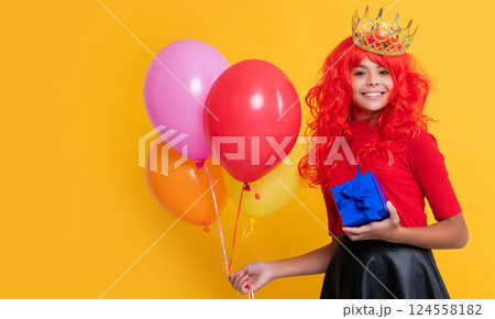 happy child in crown with present and party balloon on yellow background 124558182