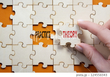 Theory or Practice symbol. Concept word Theory or Practice on wooden puzzle. Businessman hand. Beautiful orange background. Business and Theory or Practice concept. Copy space 124558343