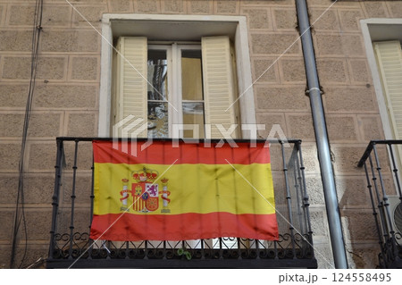 Spanish flag hanging on balcony in historic Madrid architecture scene 124558495