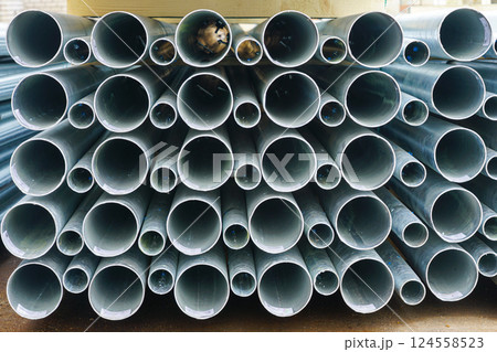 A stack of new tall conical metal lamp posts on wooden pallets at a infrastructure construction site A stack of new tall conical metal lamp posts on wooden pallets at a infrastructure construction site 124558523