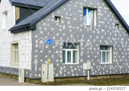 Thermal insulation of the facade of a residential building with thermal insulation material plates 124558527