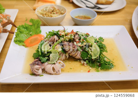 Steamed squid with lemon and spicy thai squid salad with lime and herbs 124559068