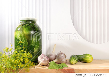 Pickled cucumbers in a jar with garlic and dill on a wooden kitchen table, rustic harvest, homemade pickling recipe, cucumbers and ingredients for pickling, home canning concept, Pickled cucumbers in a jar with garlic and dill on a wooden kitchen table, rustic harvest, homemade pickling recipe, cucumbers and ingredients for pickling, home canning concept, 124559432