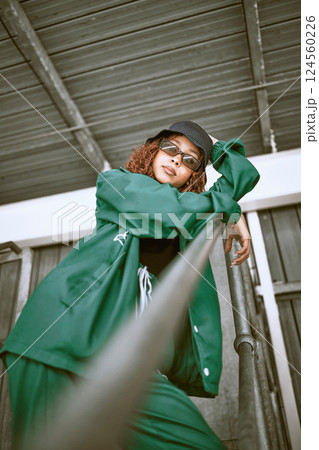 Fashion, street style and woman with green clothes, sunglasses and hat standing on stairs of an urban city building. Portrait of a cool female, hip hop or fashionable hipster model with casual outfit Fashion, street style and woman with green clothes, sunglasses and hat standing on stairs of an urban city building. Portrait of a cool female, hip hop or fashionable hipster model with casual outfit 124560226