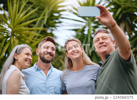 Phone, family and selfie with a man, woman and inlaws posing for a picture together in a garden or yard outdoor. Mobile, happy and smile with a senior father, mother and relatives taking a photograph 124560375