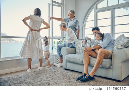 Travel, family and window in a living room of holiday house, bonding and relax while enjoying the view together. Vacation, home and happy family with kids, parents and grandparents and scenic view 124560587