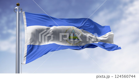 Nicaraguan national flag waving with coat of arms and blue-white tricolor 124560744