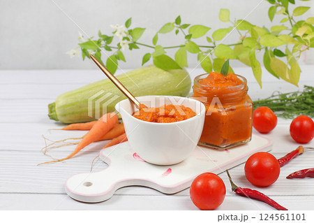 Zucchini caviar with ingredients for cooking on a concrete table, the concept of home canning and harvesting vegetables, healthy organic food, tomatoes, zucchini, carrots and peppers on the kitchen Zucchini caviar with ingredients for cooking on a concrete table, the concept of home canning and harvesting vegetables, healthy organic food, tomatoes, zucchini, carrots and peppers on the kitchen 124561101