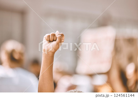 Protest, equality and fist in air in city, crowd of people in street protesting for human rights, freedom and marching. Black lives matter movement, social justice and raised hand of black person 124561144