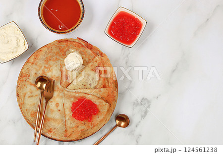 Delicious Russian pancakes with red caviar, soft cheese curd and honey on a marble table. Healthy breakfast with ingredients, natural products and traditional national cuisine, selective focus Delicious Russian pancakes with red caviar, soft cheese curd and honey on a marble table. Healthy breakfast with ingredients, natural products and traditional national cuisine, selective focus 124561238