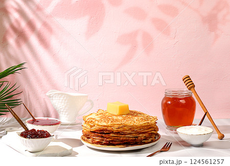 Delicious Russian pancakes with jam, soft cottage cheese and honey on a marble table. Healthy breakfast with ingredients, the concept of natural products and traditional national cuisine, advertising Delicious Russian pancakes with jam, soft cottage cheese and honey on a marble table. Healthy breakfast with ingredients, the concept of natural products and traditional national cuisine, advertising 124561257