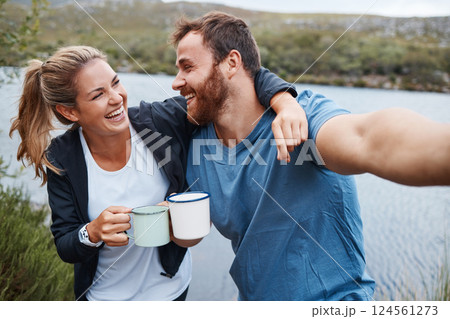 Selfie, coffee and couple by lake on vacation outdoors in nature, holiday or trip. Tea, relax and happy man and woman in love hug by river taking picture for happy memory or social media post online. 124561273