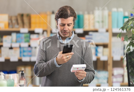 Man scans code on package of paracetamol pills to check expiration date 124561376
