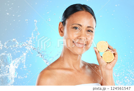 Lemon, skincare and beauty woman in studio mock up water splash for face, facial wellness and healthy glow portrait for advertising. Model with fruit for dermatology or vitamin c on blue mockup Lemon, skincare and beauty woman in studio mock up water splash for face, facial wellness and healthy glow portrait for advertising. Model with fruit for dermatology or vitamin c on blue mockup 124561547
