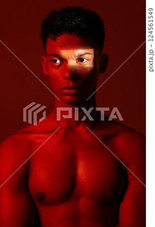 Beauty, red light and man in studio for health, wellness and skincare with a spotlight reflection. Body, self care and healthy male model from Mexico with cosmetics isolated by a red background. 124561549
