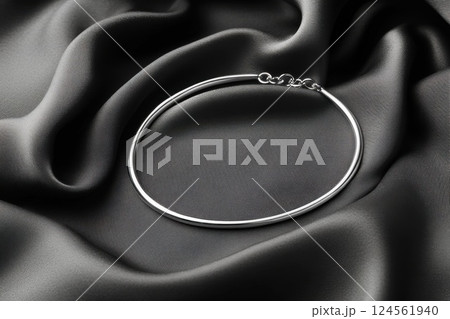 Elegant silver choker necklace on smooth velvet fabric showcasing minimalist design 124561940