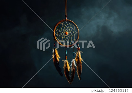 Native American dreamcatcher with detailed feathers and beads on a dark backdrop 124563115