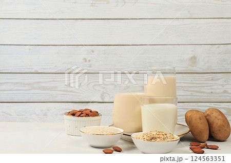Vegan alternative milk lactose and gluten free, allergy free, almonds, rice, oats, potatoes and glasses of drinks on wooden table, healthy eating concept, diet food, weight loss, Vegan alternative milk lactose and gluten free, allergy free, almonds, rice, oats, potatoes and glasses of drinks on wooden table, healthy eating concept, diet food, weight loss, 124563351