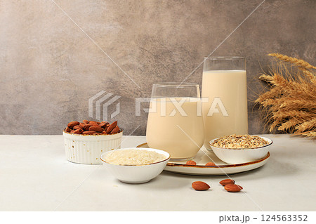 Vegan alternative milk lactose and gluten free, allergy free, almonds, rice, oats and glasses of drinks on the kitchen table, healthy eating concept, diet food, weight loss 124563352