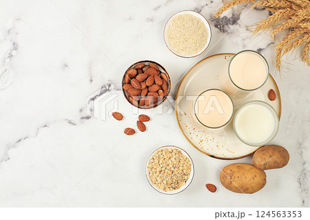 Vegan alternative milk lactose and gluten free, allergy free, almonds, rice, oats, potatoes and glasses with drinks on the kitchen table, healthy eating concept, diet food, weight loss, Vegan alternative milk lactose and gluten free, allergy free, almonds, rice, oats, potatoes and glasses with drinks on the kitchen table, healthy eating concept, diet food, weight loss, 124563353