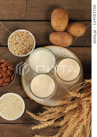 Vegan alternative milk lactose and gluten free, allergy free, almonds, rice, oats, potatoes and glasses of drinks on wooden table, healthy eating concept, diet food, weight loss, Vegan alternative milk lactose and gluten free, allergy free, almonds, rice, oats, potatoes and glasses of drinks on wooden table, healthy eating concept, diet food, weight loss, 124563356