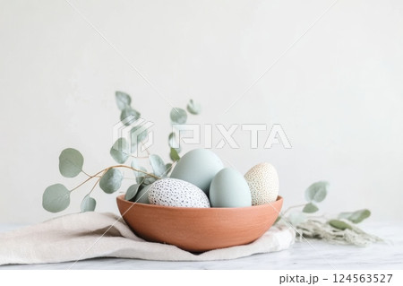 Minimalist Easter centerpiece featuring dotted eggs and eucalyptus leaves arranged on a marble countertop, ideal for festive decoration and celebration 124563527